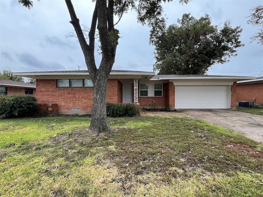 Ranch-style home with brick siding, driveway, a front yard, and a garage
