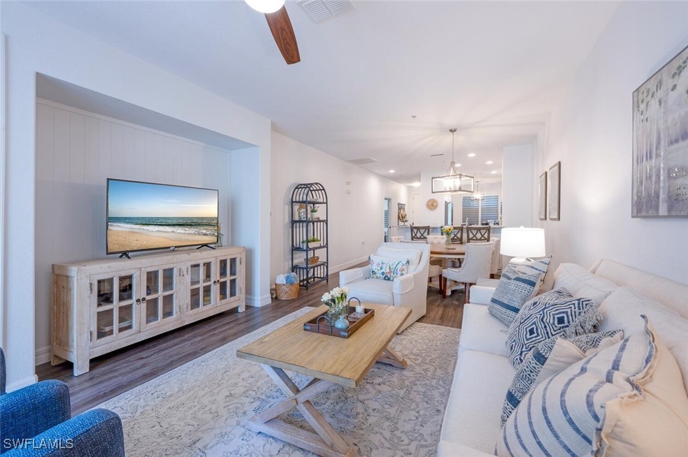 Living room with ceiling fan, visible vents, baseb