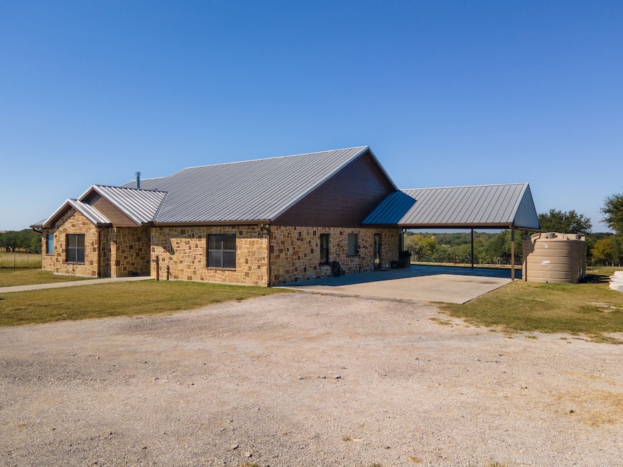 Ranch-style home with driveway, a metal roof, brick siding, a front lawn, and a carport