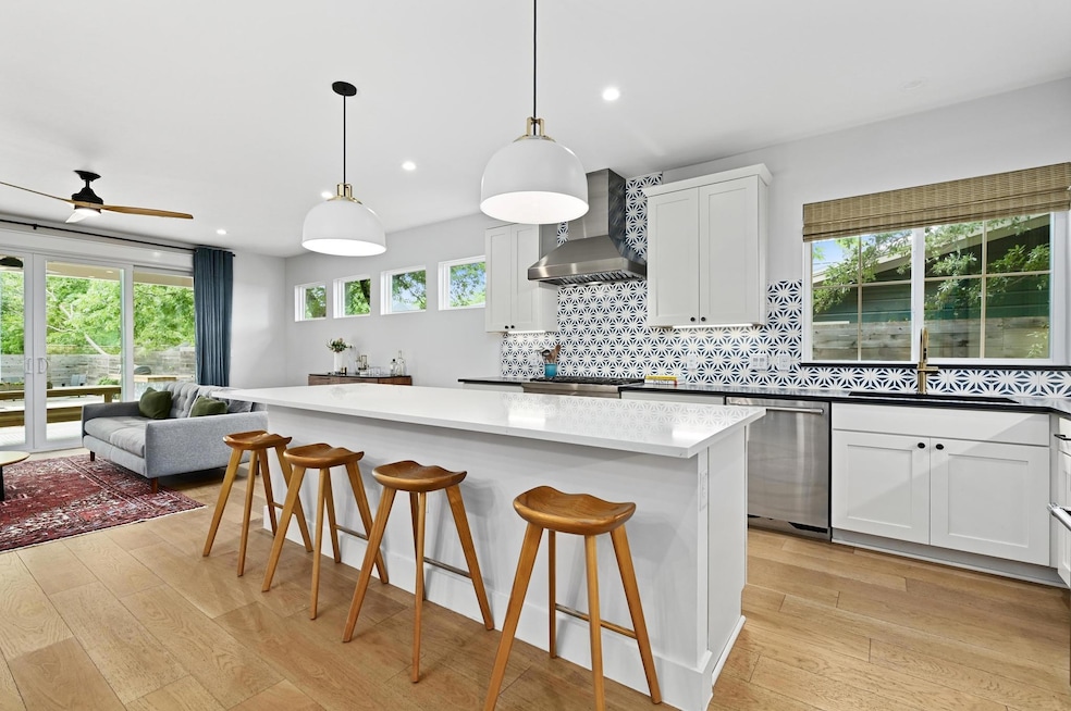 Kitchen with a sink, wall chimney exhaust hood, l