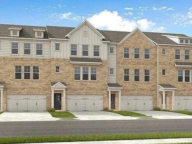 View of front of home with driveway, board and batten siding, and a garage
