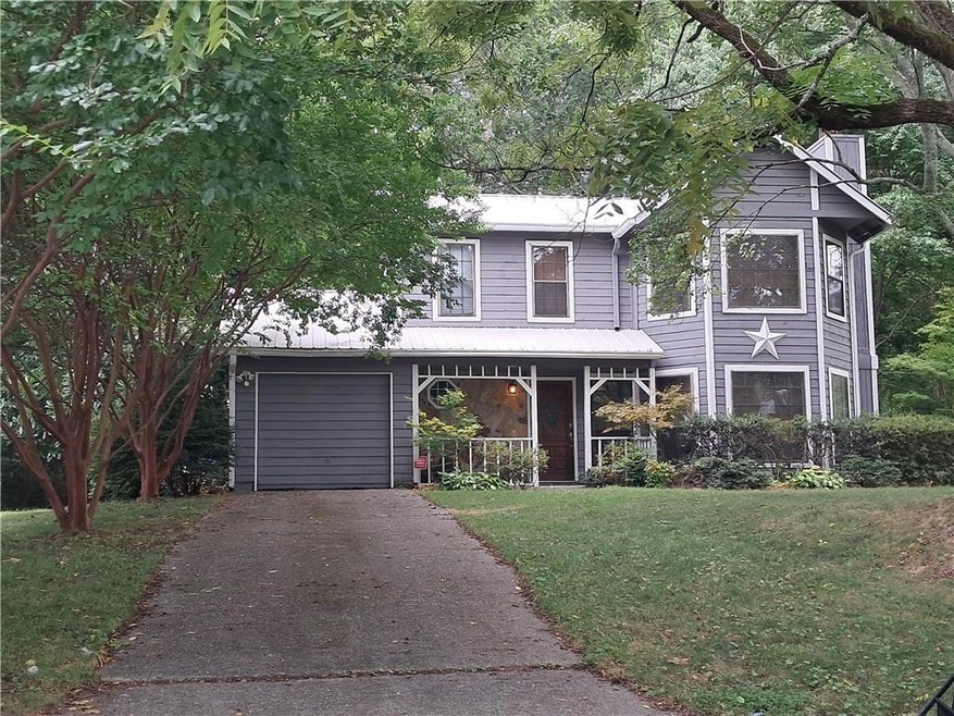 View of property with a garage and a front lawn