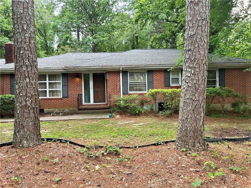 Ranch-style home featuring brick siding, a chimney