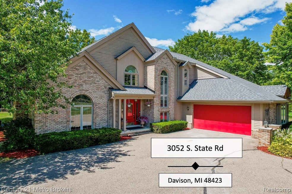 Traditional-style house with brick siding, a shingled roof, concrete driveway, and a garage