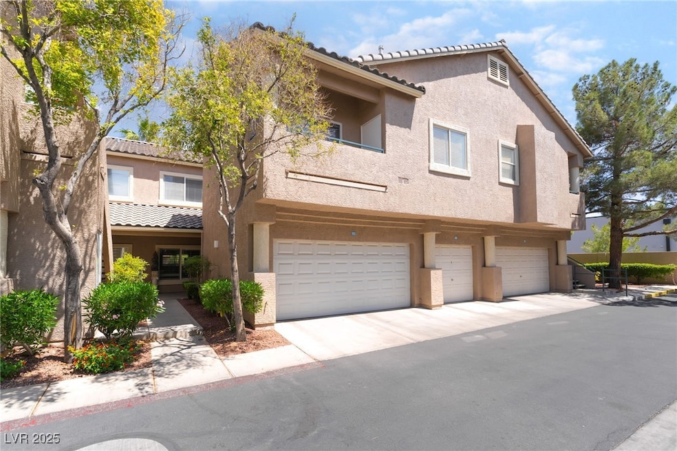 View of property featuring stucco siding, an attac