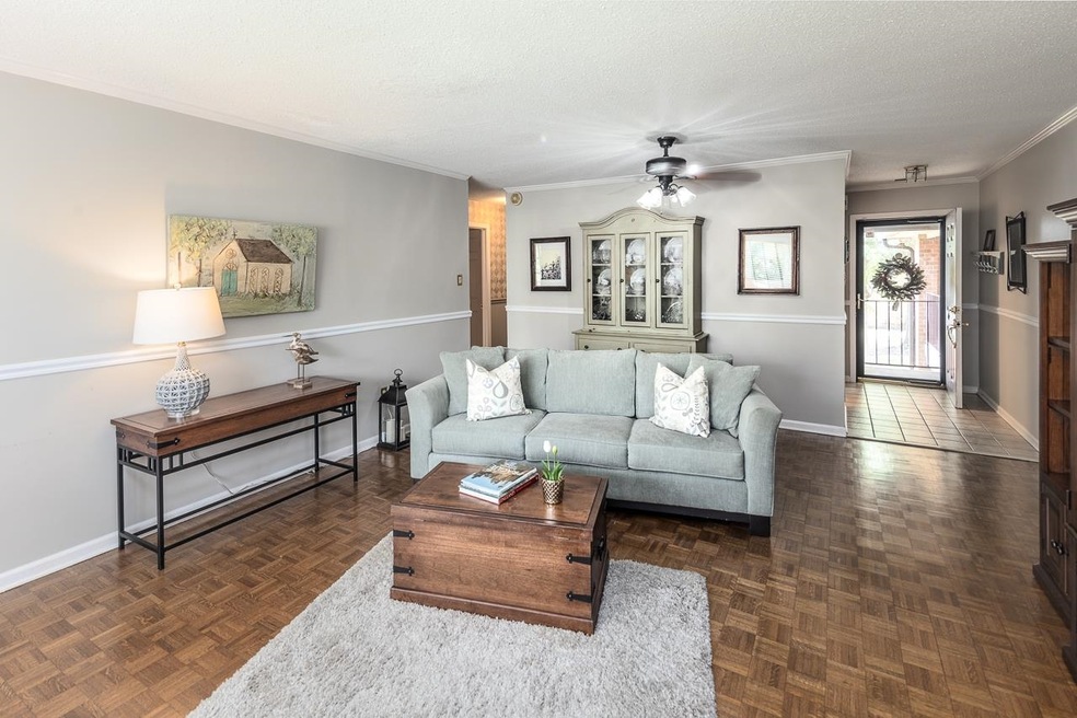 Living room with ceiling fan, dark parquet floorin