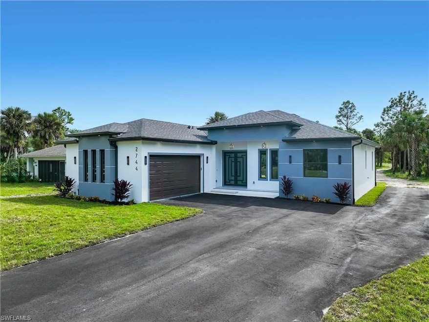 Prairie-style house with a shingled roof, stucco siding, asphalt driveway, and an attached garage