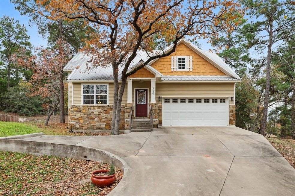 Craftsman house with concrete driveway, stone siding, a metal roof, and a garage
