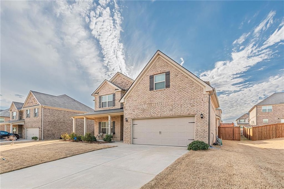View of front facade with an attached garage, brick siding, and driveway
