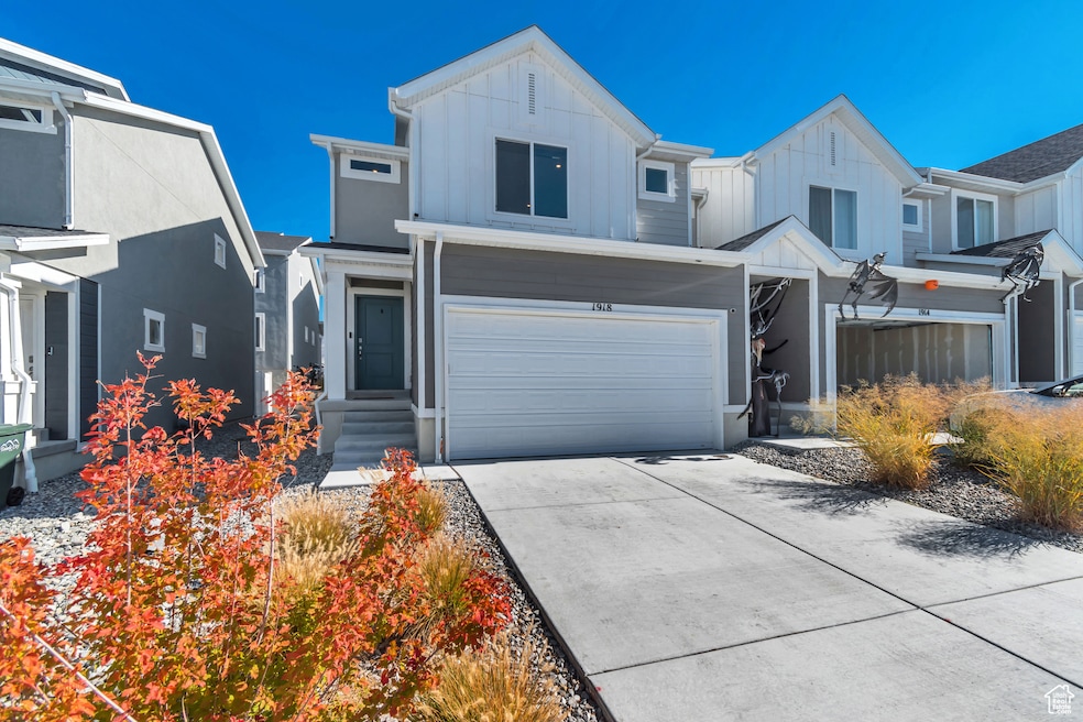 View of front of home with board and batten siding, concrete driveway, and an attached garage