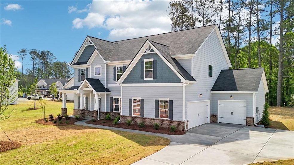 Craftsman-style home with concrete driveway, brick siding, a front yard, and a garage