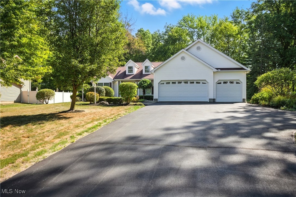 View of front of house with asphalt driveway and a garage