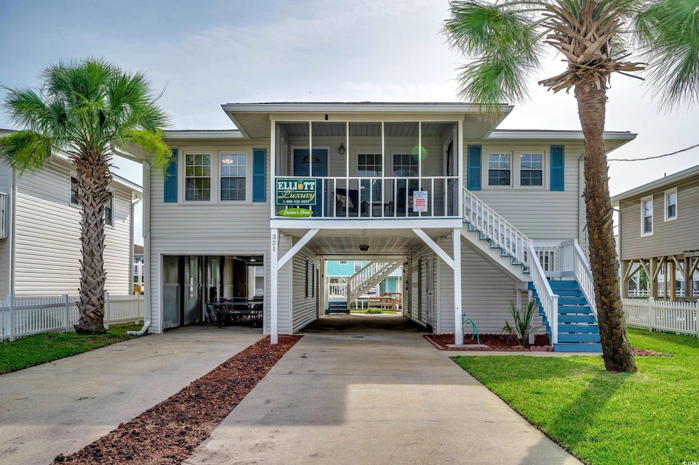 View of front facade featuring a carport, stairs, concrete driveway, and a sunroom