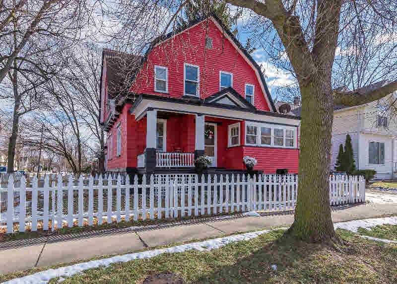 Fenced in front yard and roofed porch with sunroom