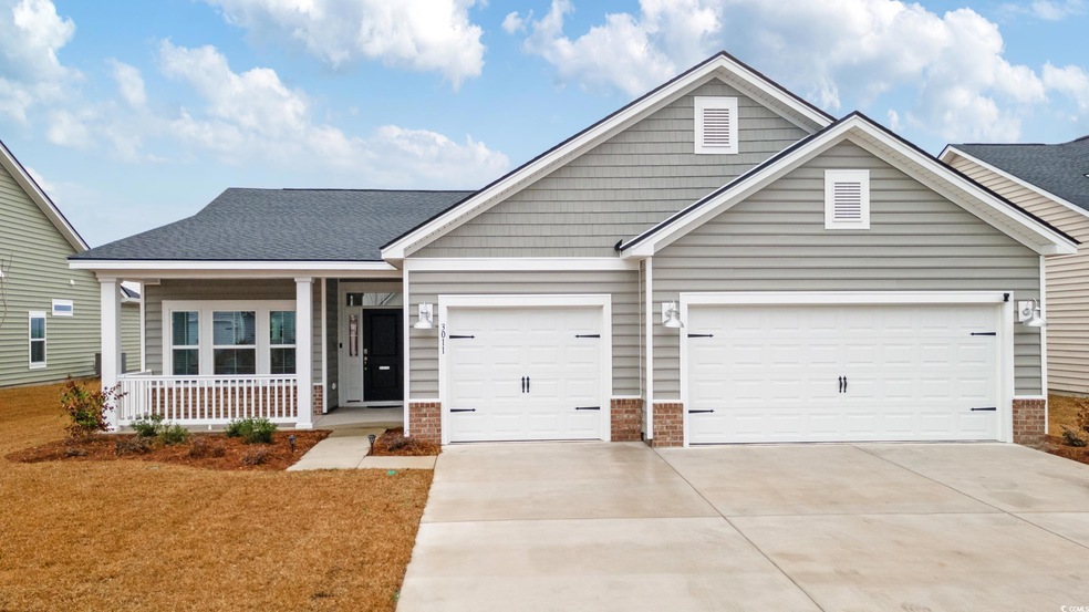 View of front of home with a garage and covered po