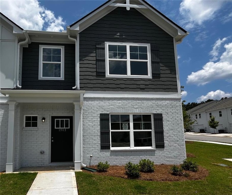 Craftsman house featuring a front lawn and brick siding