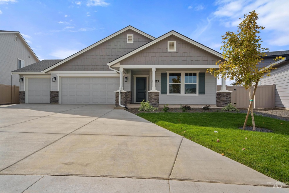 Craftsman house featuring covered porch, a garage, concrete driveway, and stone siding