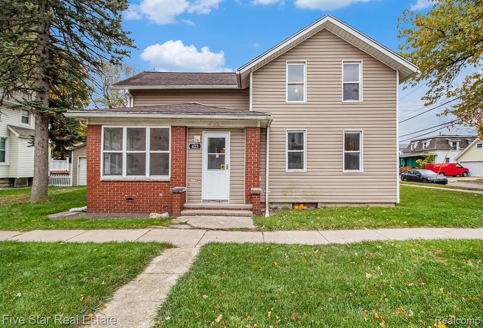 Traditional home featuring a front lawn, brick siding, and roof with shingles