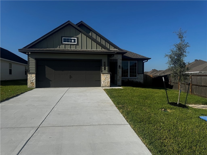 View of front facade with stone siding, board and batten siding, concrete driveway, and an attached garage