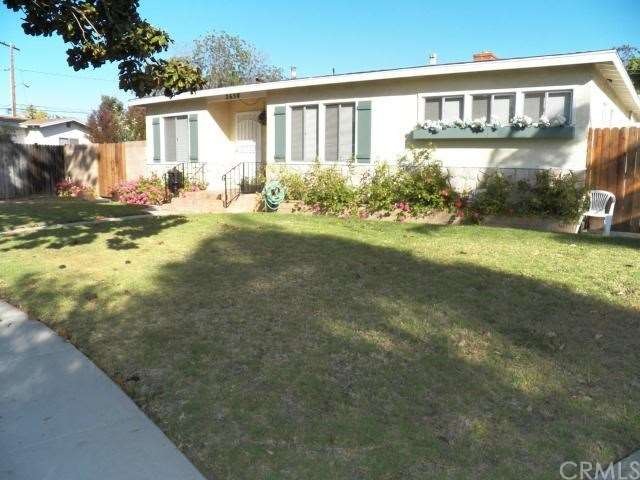 Exterior front view of home, with side gated yard 