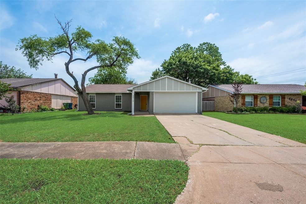 Single story home with board and batten siding, a front yard, a garage, and driveway