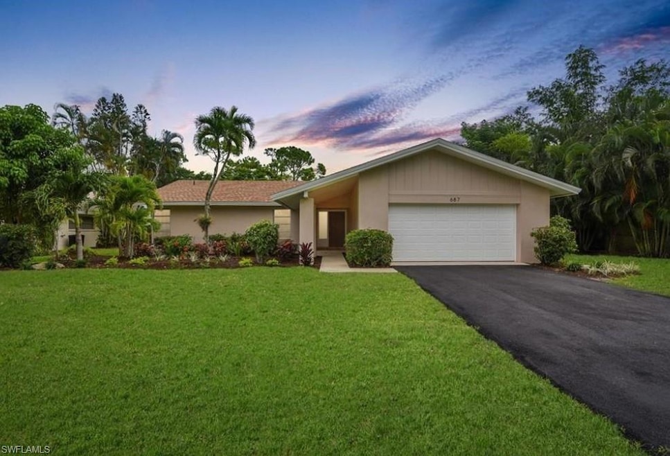 Single story home with a garage and a yard