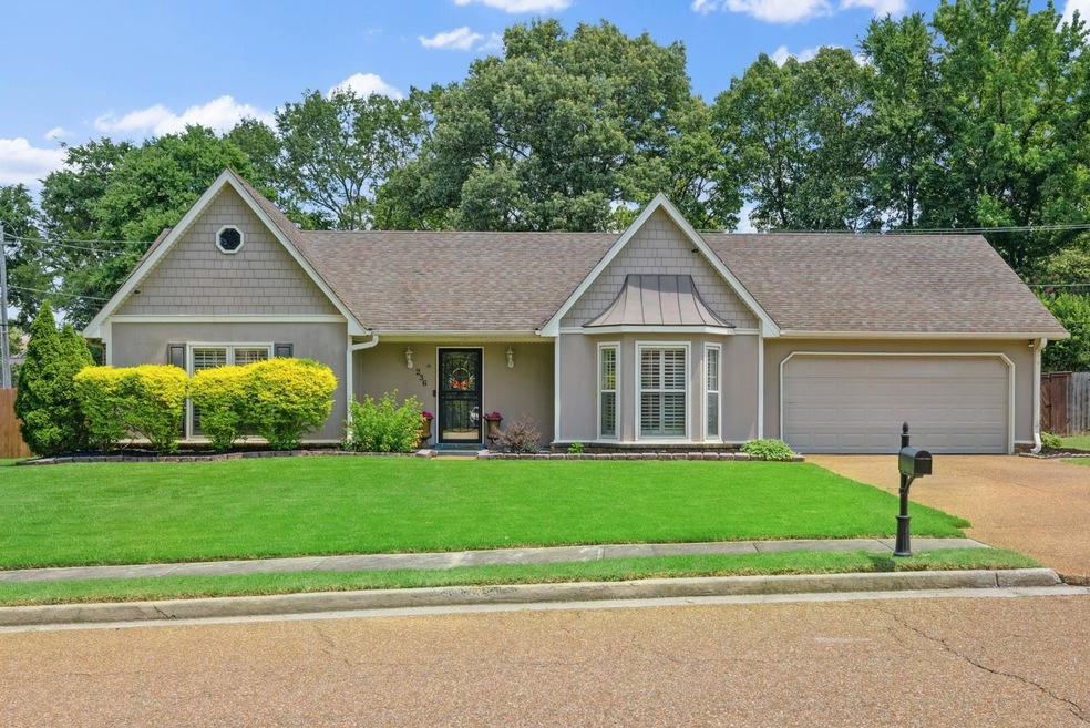 View of front of home with driveway, a garage, a front yard, a shingled roof, and stucco siding