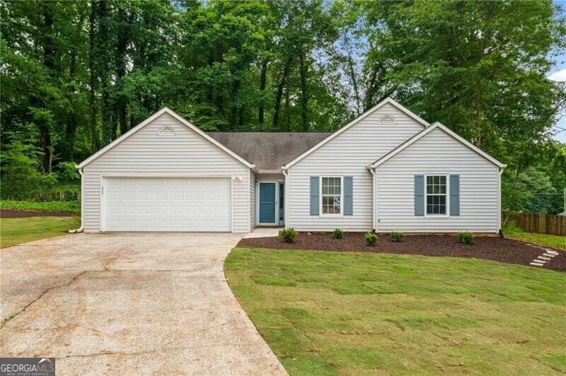 Ranch-style home with driveway and an attached garage