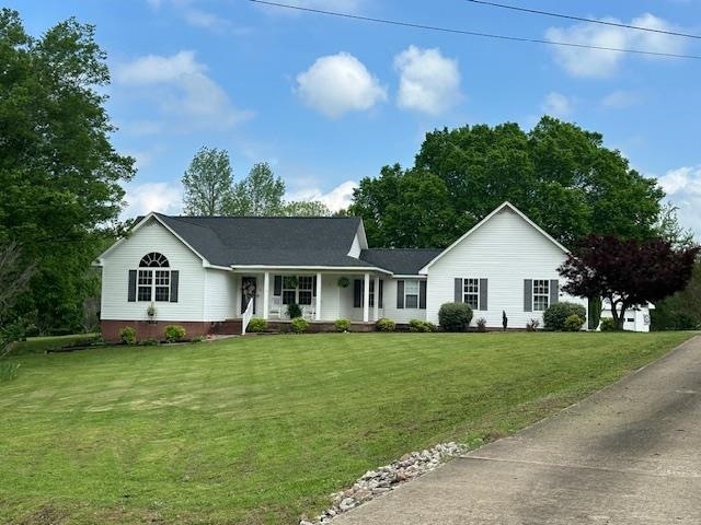 Ranch-style home with a porch and a front lawn