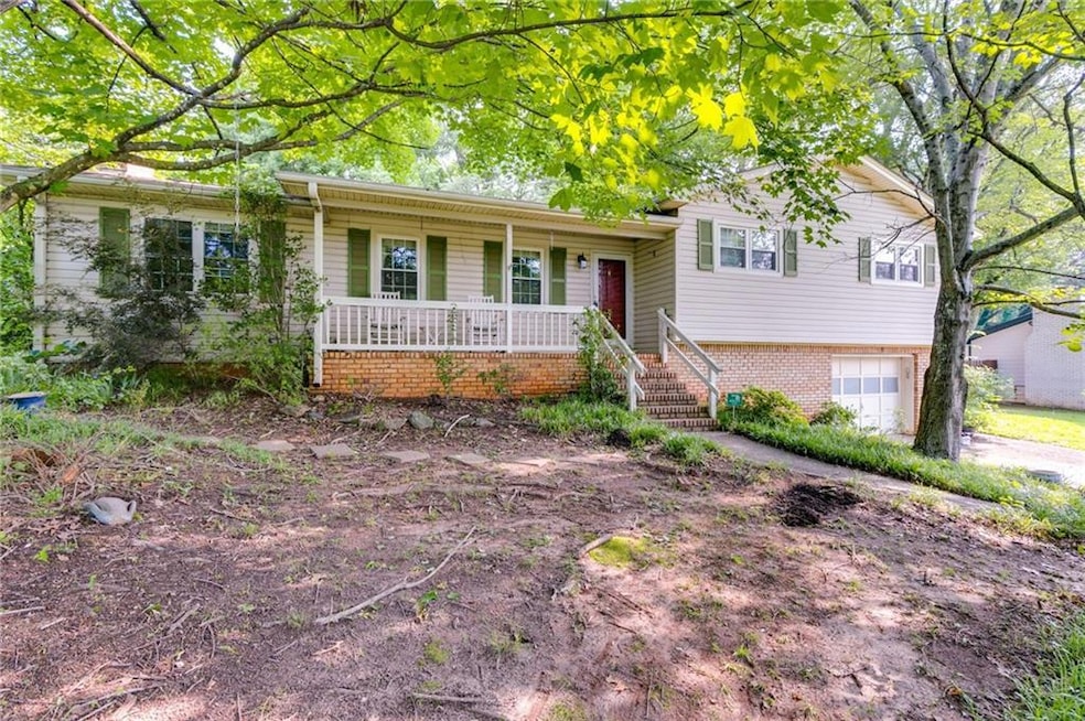 Tri-level home featuring covered porch and a garage