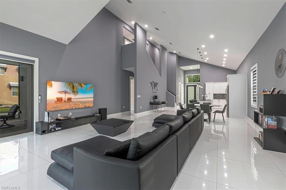 Living room with high vaulted ceiling and recessed lighting