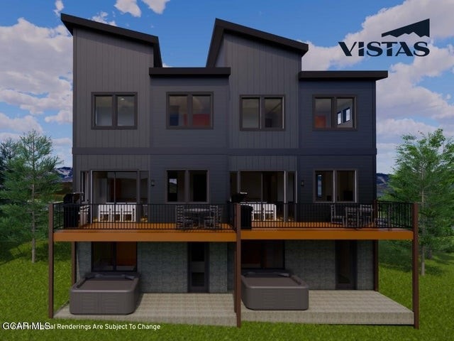 Back of property featuring a yard, a deck, and sto