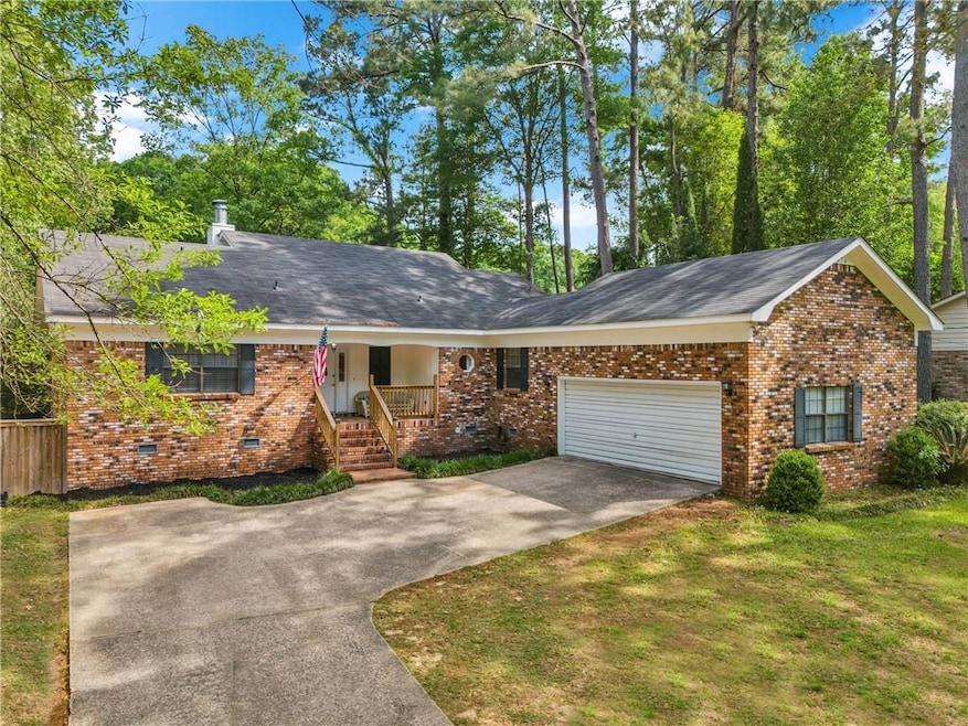 Ranch-style home featuring a front lawn, concrete 