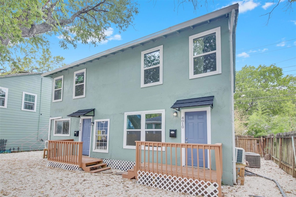 Rear view of property featuring a deck and stucco siding