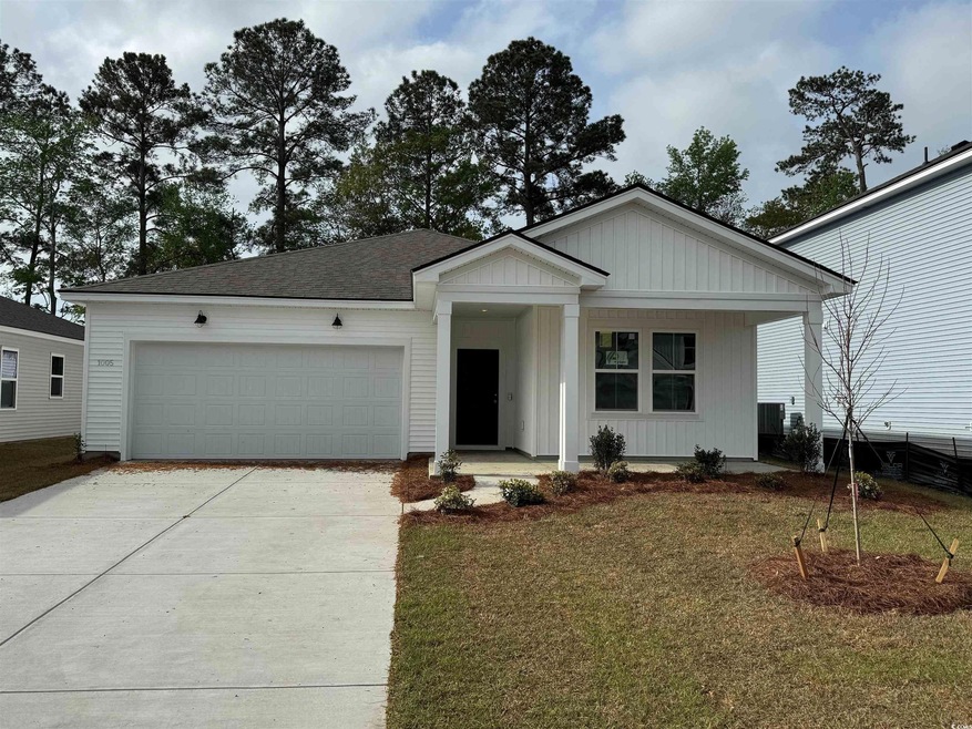View of front of house with a garage, a porch, dri