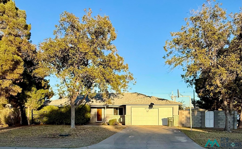 Ranch-style home featuring concrete driveway, an attached garage, and roof with shingles