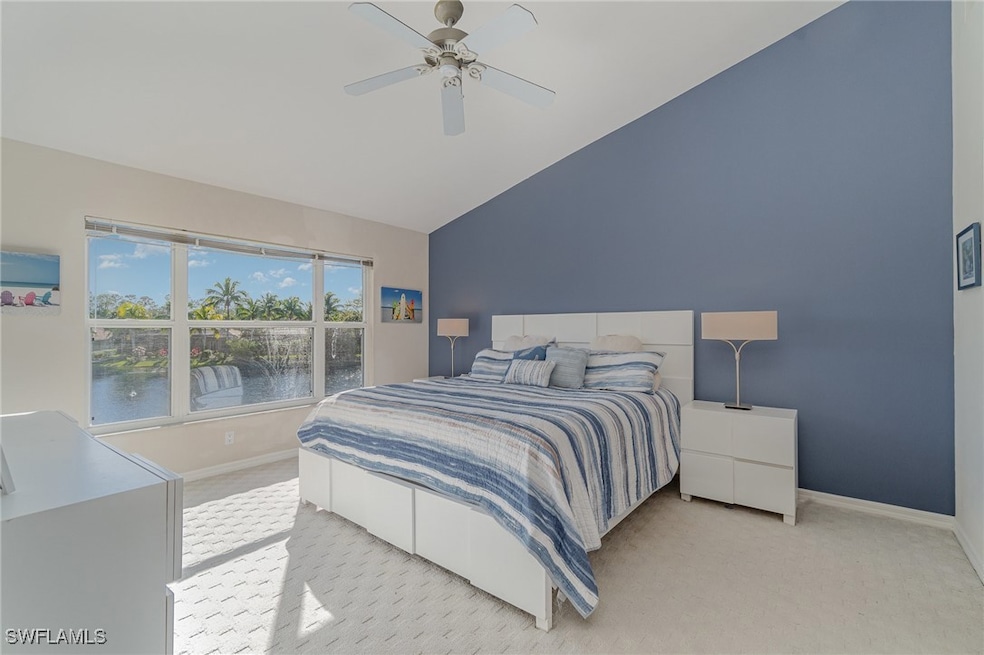 Primary bedroom featuring high vaulted ceiling, ceiling fan, and a water view