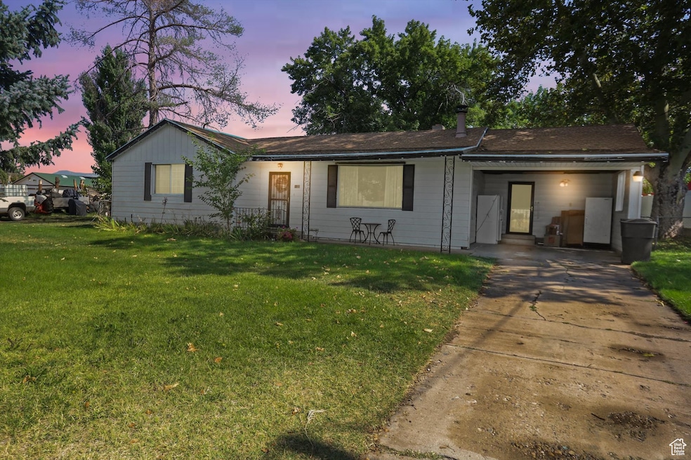 Ranch-style home featuring a yard and concrete driveway