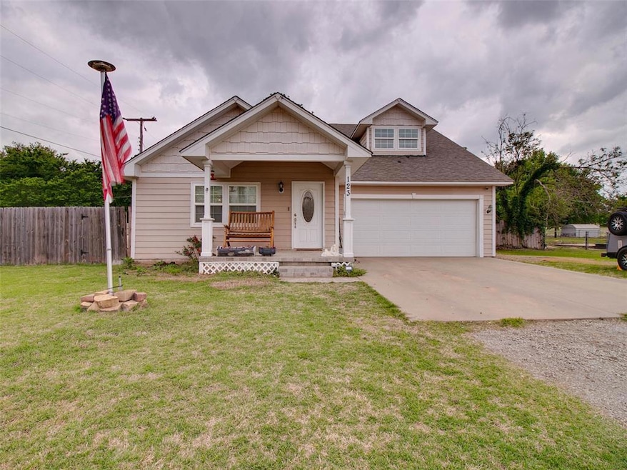 View of front of property featuring a porch, a gar
