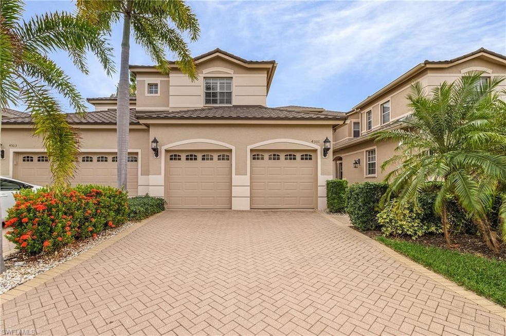 View of front of home with decorative driveway, a garage, stucco siding, and a tiled roof