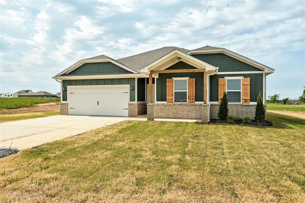 Craftsman-style house with board and batten siding, driveway, an attached garage, and a front yard