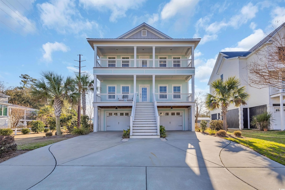 Raised beach house with a garage, driveway, stairw