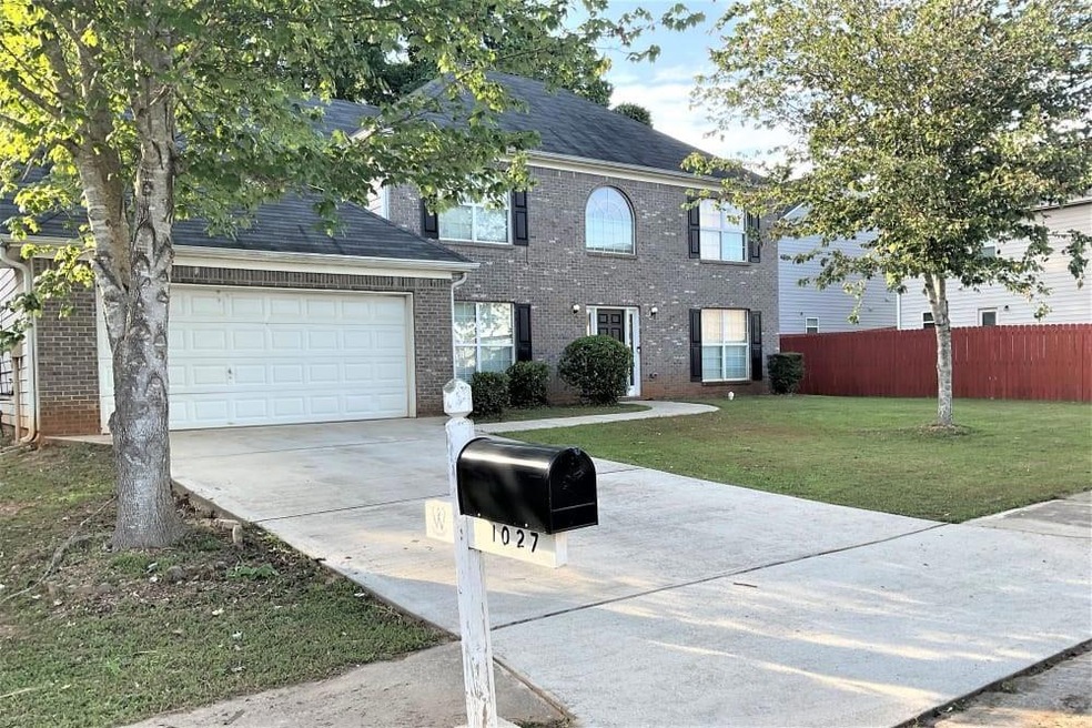 Colonial inspired home featuring a garage and a front yard