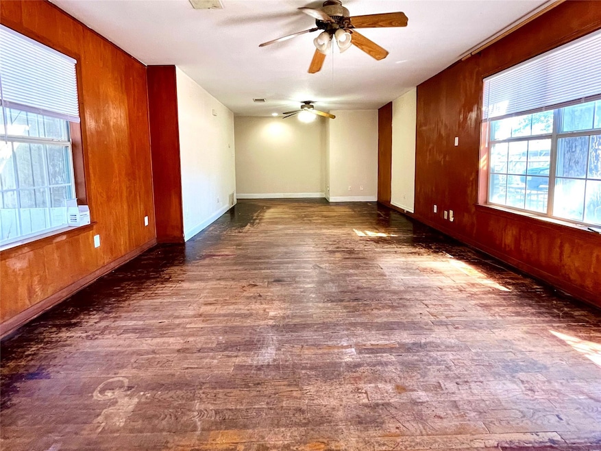 Spare room featuring wood walls, dark wood-style