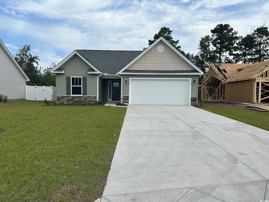 View of front of home featuring a garage, stone si