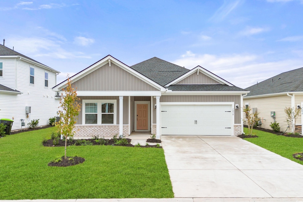 Craftsman house with a garage and a front lawn