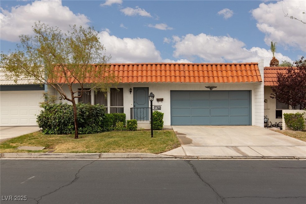 View of front of property with a front yard, a gar