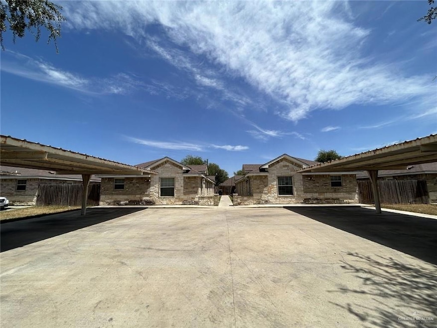 View of front of house with covered parking, fence, and stone siding