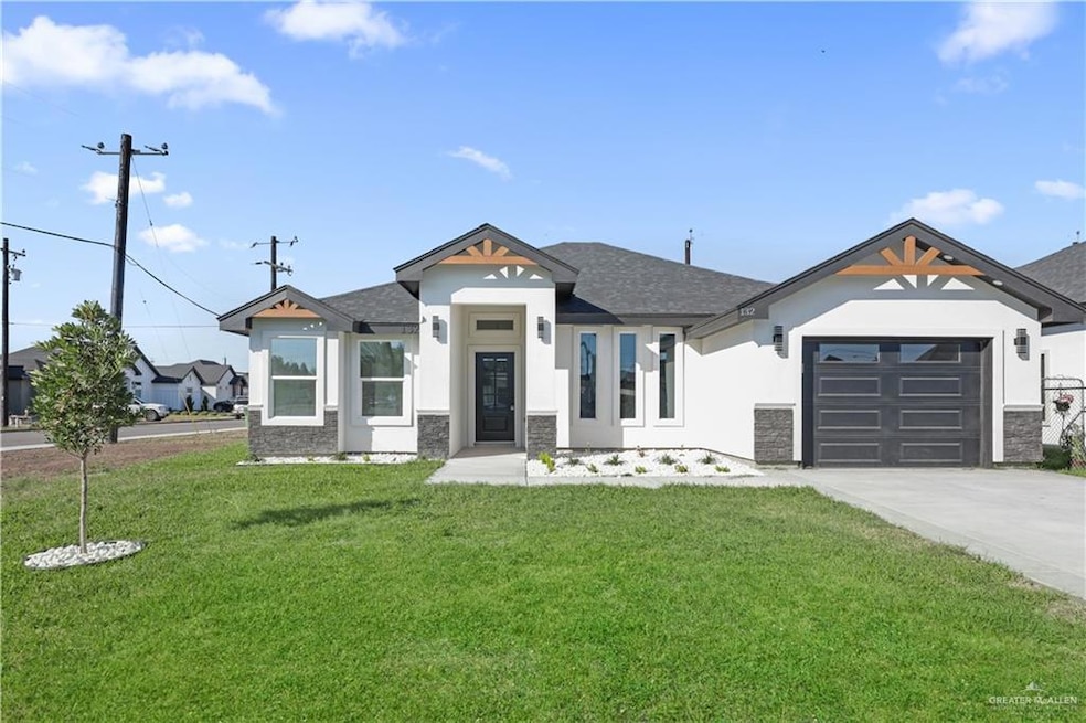 View of front of property featuring an attached garage, concrete driveway, roof with shingles, stucco siding, and a front lawn