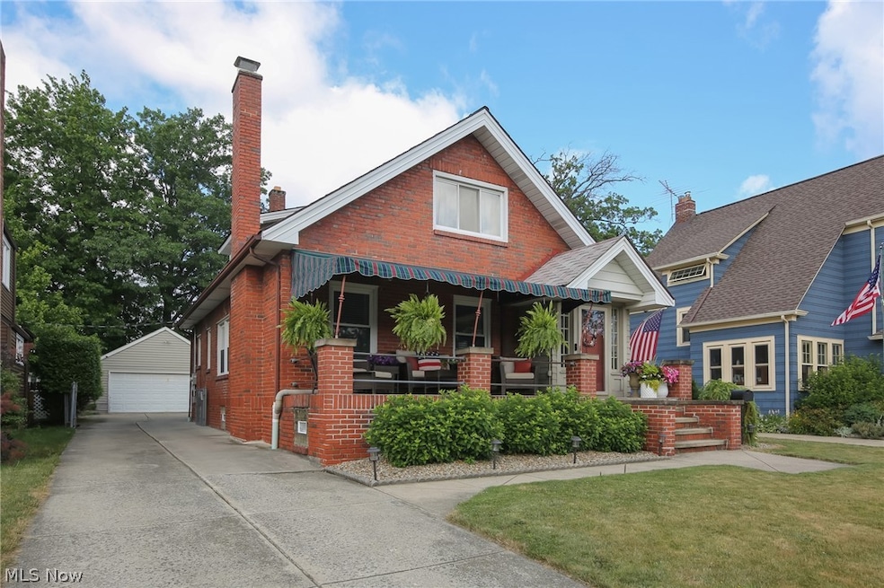 View of front of home with a garage, a front lawn, and an outdoor structure